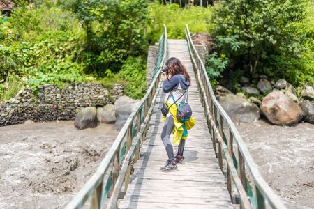 Kullu, Himachal Pradesh, India - August 31, 2018 : Traveler Girl on wooden bridge leads to house in...