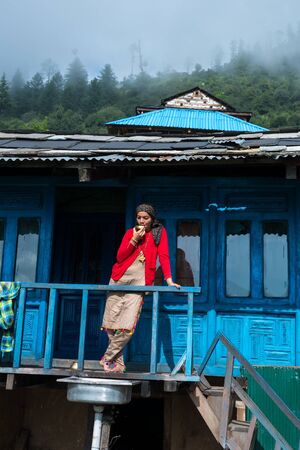Kullu, Himachal Pradesh, India - September 01, 2018 : woman in balcony of traditional wooden house...