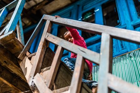 Kullu, Himachal Pradesh, India - September 01, 2018 : Himalayan kid at traditional wooden house in mountain, Indiaのeditorial素材