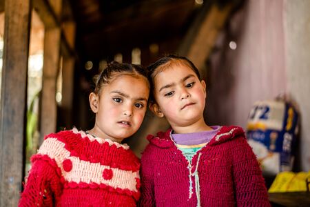 Kullu, Himachal Pradesh, India - April 01, 2019 : Portrait of twins himachali girl near her house on the street in Himalayan village in indiaのeditorial素材