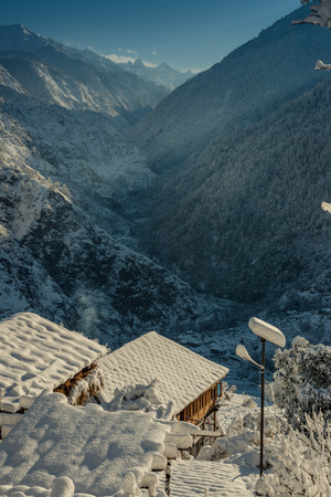 Snow covered wooden house in mountains - Majestic winter landscape in himalayas -の写真素材