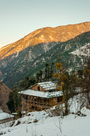 Snow covered wooden house in mountains - Majestic winter landscape in himalayas -の写真素材
