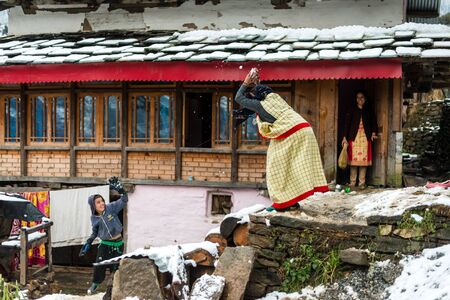 Kullu, Himachal Pradesh, India - January 25, 2019 : himachali woman in traditional dress playing in snow with kid in winters -のeditorial素材