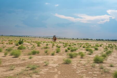 Jaisalmer, Rajasthan, India - July 29, 2019 : Tourist Camel Safari in Thar Desert -