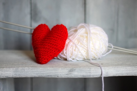 Photo of ball of wool and heart on wooden background の写真素材