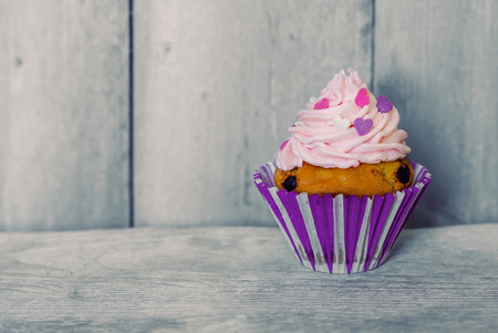 Photo of cute cupcake on wooden backgroundの写真素材