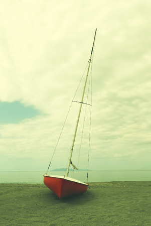 This photo of red boat on coastlineの写真素材