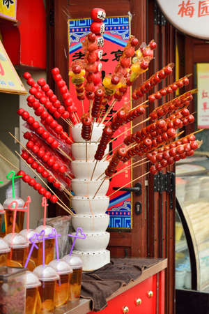 Hawthorn coated with sugar selling in a street of chinaの写真素材