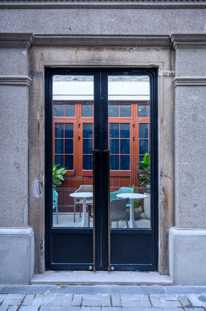 Old wooden door with a glass door and a table in a cafeの写真素材