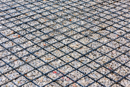 Closeup of steel mesh for construction site with pebbles.の写真素材