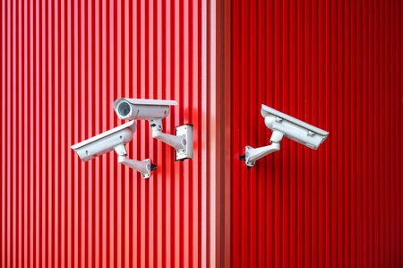CCTV cameras on the red wall of a building. Security camera.