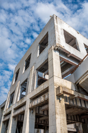 Abandoned building under construction with blue sky and white clouds.の写真素材