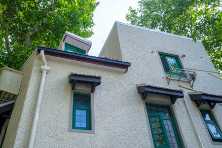Thai style house with white walls and green trees in Thailand.の写真素材