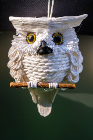White owl doll on a wooden stick with reflection on the water.の写真素材