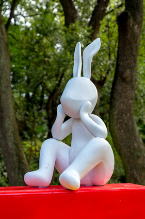Statue of a rabbit sitting on a red chair in the parkのeditorial素材
