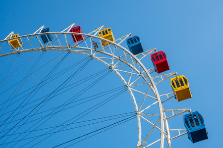 Colorful ferris wheel against blue sky in sunny summer day.の写真素材