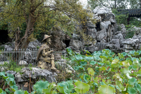 Sculpture of a man sitting in a lotus pondの写真素材