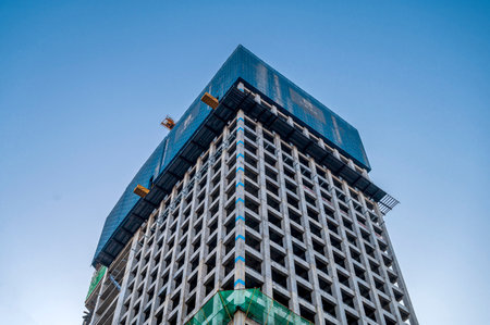 Construction of a high-rise building with a blue sky background.の写真素材