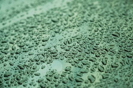 Water drops on green car surface. Abstract background and texture for design.の写真素材