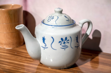 White porcelain teapot on a wooden table in the kitchenの写真素材