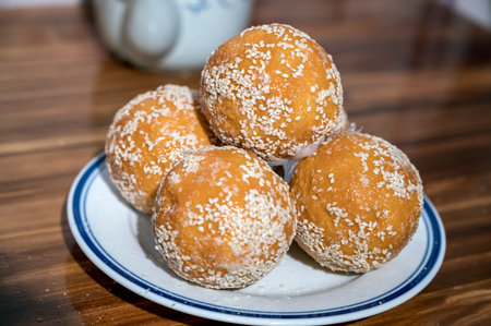 Baked donuts with sesame seeds on a white plate.