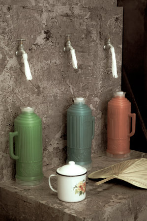 Coffee cups and teapot on the wall. Toned.