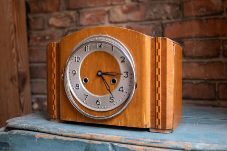 Vintage alarm clock on wooden table with brick wall in the background