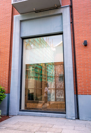 Facade of a modern building with a glass door and a brick wall