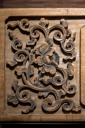 Wooden carved ornament on a wooden board. Close-up.
