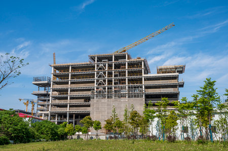 Multi-storey building under construction with crane on blue sky background