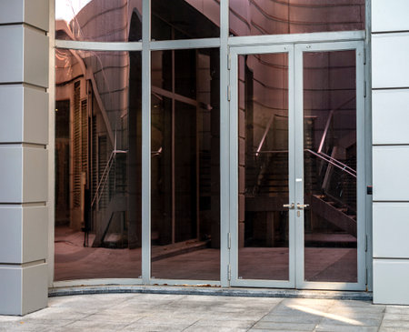 Entrance to modern office building with metal doors and concrete floor.の写真素材