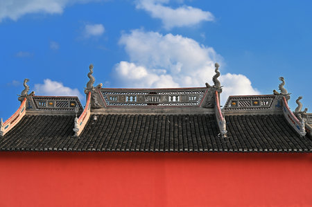 Roof of an ancient Chinese temple against a blue sky with cloudsの写真素材