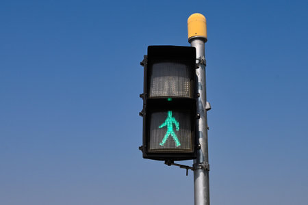 Traffic light with a green signal on a blue sky background.の写真素材