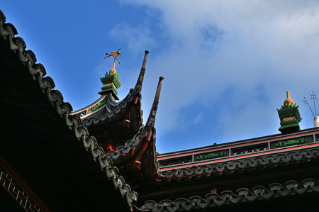 The roof of a Buddhist temple with a cross on the roof.の写真素材
