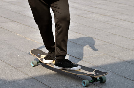skateboarder legs riding on skateboard on the street.