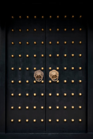Traditional Chinese door with gold knocker, close-up view.の写真素材
