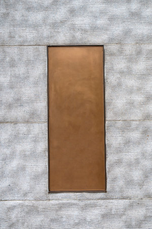 Blank brown signboard on a white wooden wall with shadows.の写真素材