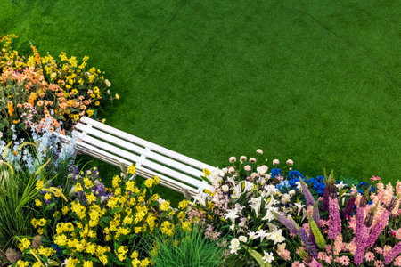 Flower garden with white bench on green grass, top view.の写真素材