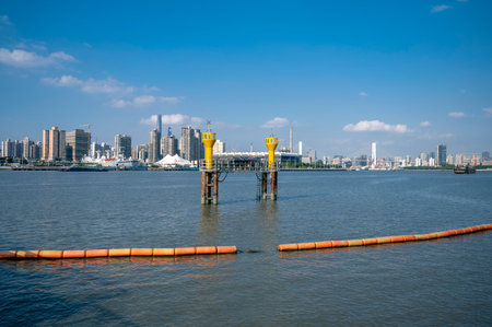 Pier in the middle of the river with cityscape background.