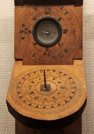 A closeup shot of a vintage compass on an old wooden surfaceのeditorial素材