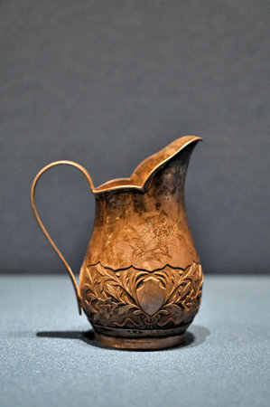 Antique bronze jug on a gray background. Side view. Copy space.のeditorial素材