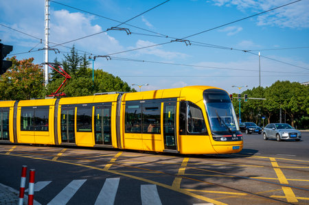 Public transport yellow trams on a street in Shanghai, Chinaのeditorial素材