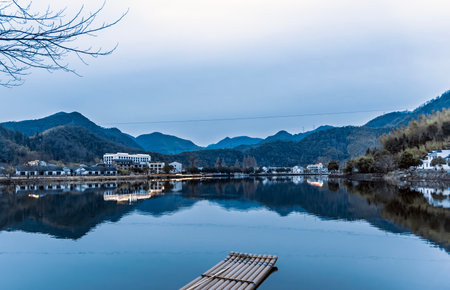 Mountain landscape with lake and wooden bridge during twilight in winter.の写真素材
