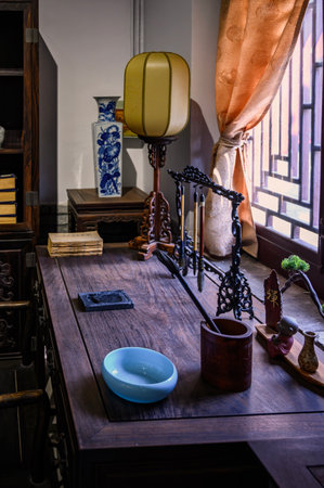 Wooden table with a lamp and a blue cup of coffee.
