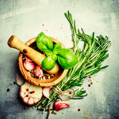 Herbs, spices, garlic and sea salt in a wooden mortar and pestle, a top view, food backgroundの写真素材