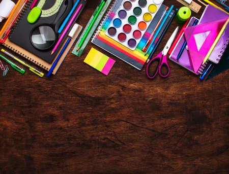 Back to school background with space for text, notebooks, pens, pencils, other stationery on wooden...