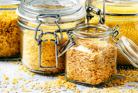 Assorted cereals and grains in glass jars for storage, selective focusの写真素材