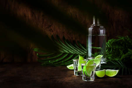 Cachaca - Brazilian strong alcoholic beverage from cane sugar, lime vodka, vintage wooden background, selective focusの写真素材