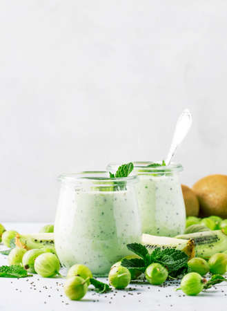 Smoothies from gooseberry, kiwi and yogurt with chia seeds, gray background, selective focusの写真素材