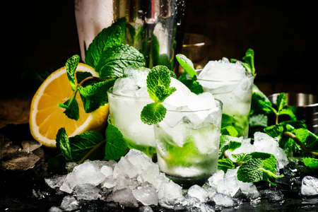 Alcoholic cocktail vodka smash with vodka, sugar syrup, soda, lime, mint and crushed ice, black background, selective focusの写真素材